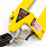 Close-up of the yellow 2000kg pallet truck head showing the 2000 KG CAPACITY decal and the safety warning label