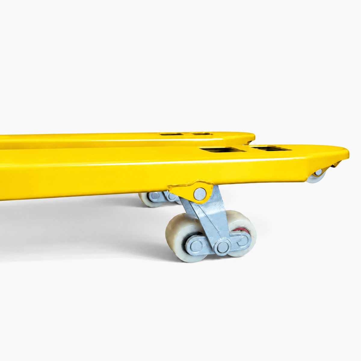 Underside of the yellow pallet truck forks showing the paired tandem load rollers on their linkage